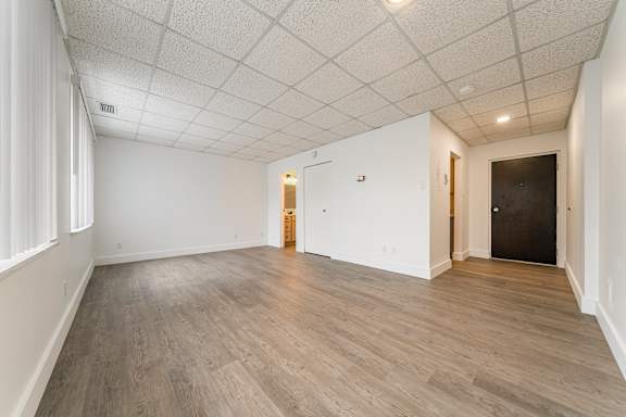 A room with wooden flooring and white walls.