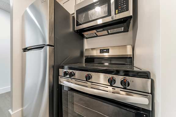 A modern kitchen with a stainless steel refrigerator and oven.