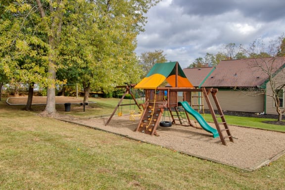 Playground with a swing set and slides in a park at Hunt Club Apartments, Copley, 44321