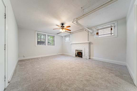 A room with a fireplace and a ceiling fan.