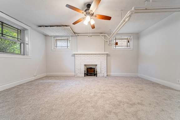 A room with a fireplace and a ceiling fan.