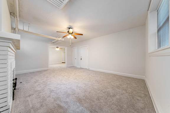 A room with a ceiling fan and carpeted floor.