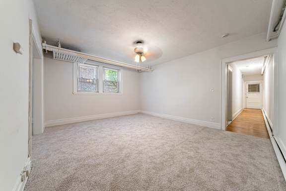 A room with a carpeted floor and a window.