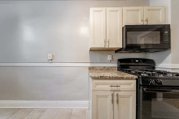 A kitchen with a black microwave above a black stove.