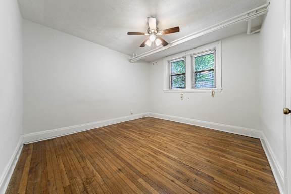 A room with a ceiling fan and a window.