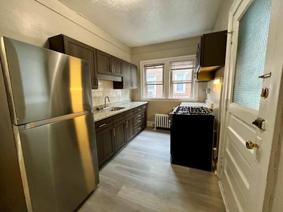 a kitchen with stainless steel appliances and black cabinets at Heights Collection Apartments, Cleveland Heights