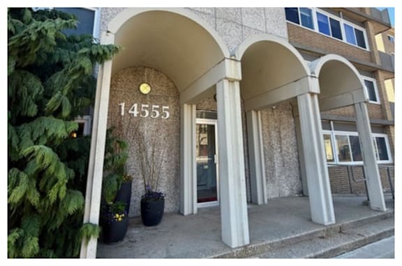 The image shows a building entrance with a number 14555 on it.