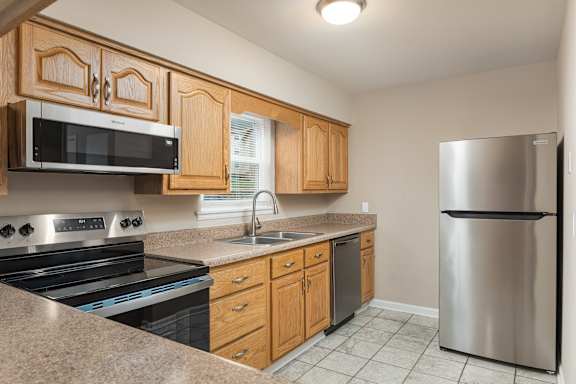 A kitchen with wooden cabinets and stainless steel appliances.