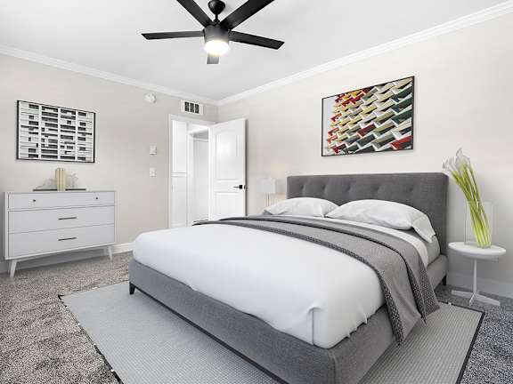 A bedroom with a large bed and a ceiling fan.