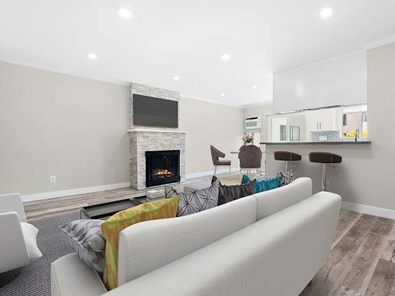 A modern living room with a fireplace and a white couch.