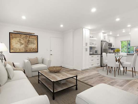 A modern living room with a white sofa set, a coffee table, and a framed map on the wall.