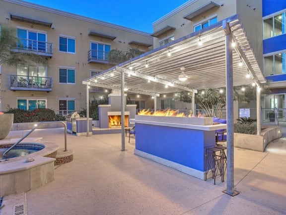 a bar with a fire pit in front of an apartment building at The Mosaic on Broadway, San Antonio, TX, 78215