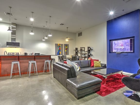 a living room with a blue accent wall and a kitchen at The Mosaic on Broadway, Texas, 78215