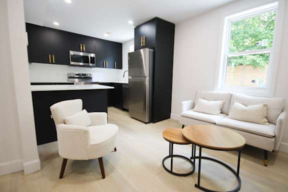 A black and white kitchen with a white chair and table.