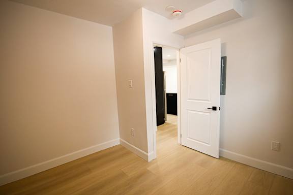 A room with a white door and a black object on the floor.