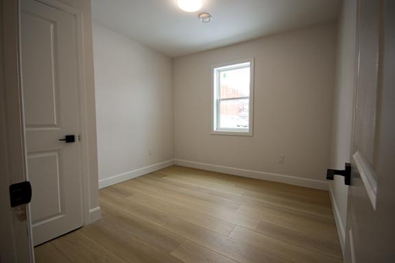 A room with a wooden floor and a window.
