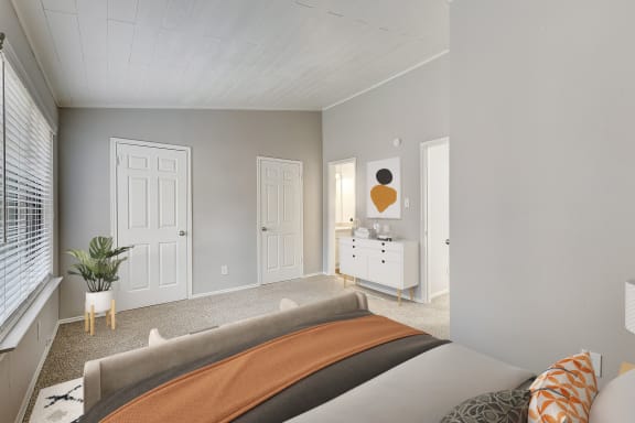 a bedroom with grey walls and a bed with an orange blanket