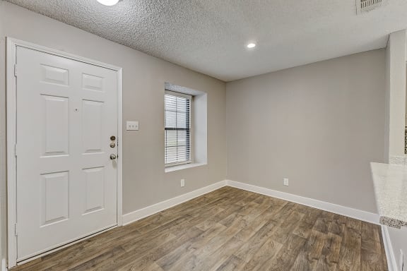 a bedroom with hardwood floors and a white door