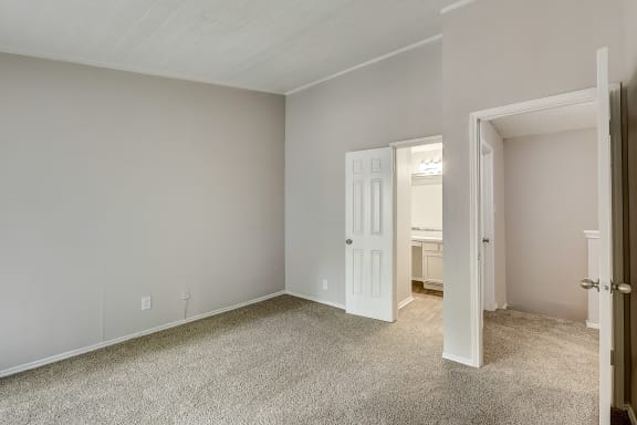 a bedroom with grey walls and carpet