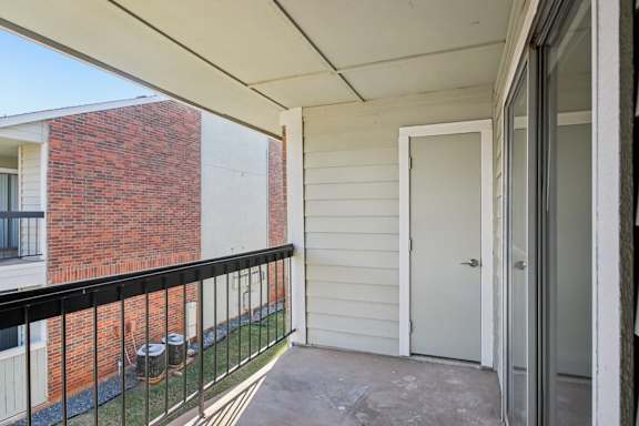 A balcony with a black railing and a white door.