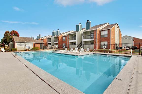 A large swimming pool in front of apartment buildings.