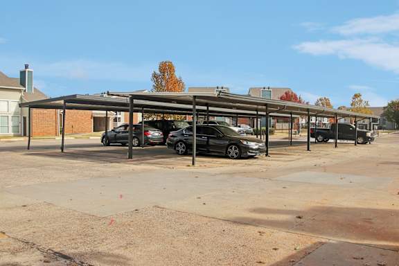 A parking lot with cars and a building in the background.