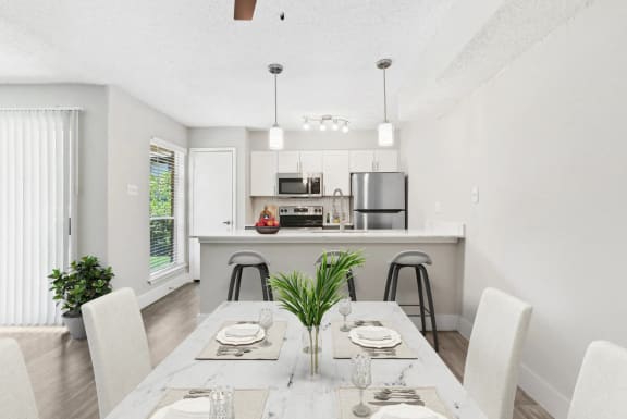 a dining room and kitchen with a table and chairs