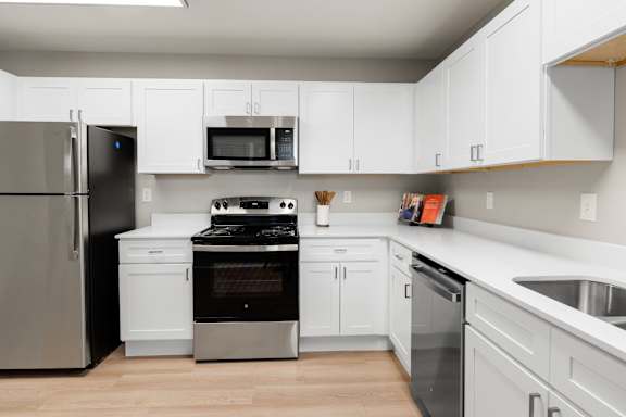 A modern kitchen with white cabinets and stainless steel appliances.