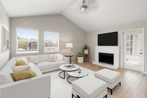 A living room with a white couch, a coffee table, and a fireplace.