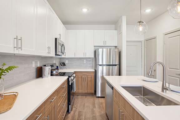 A modern kitchen with wooden cabinets and stainless steel appliances.