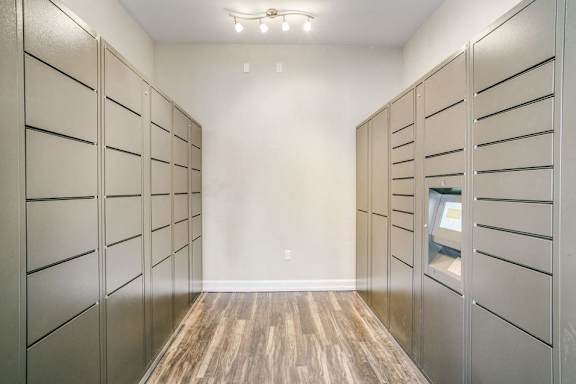 A long hallway with wood floors and a row of lockers on the left.