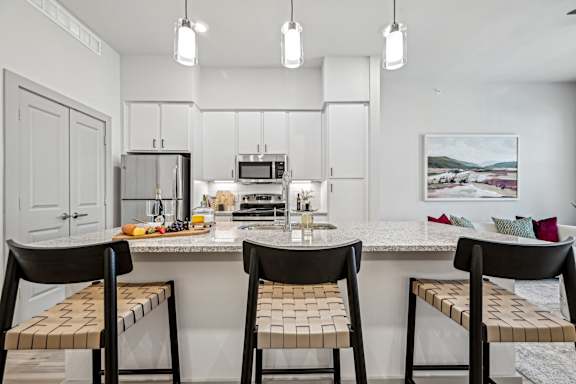 a kitchen with a marble counter top with three stools