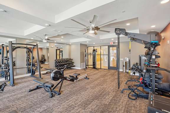 a gym with weights and a ceiling fan