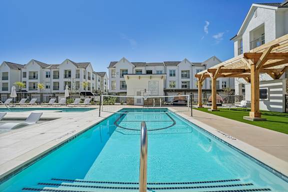 a swimming pool with apartment buildings in the background