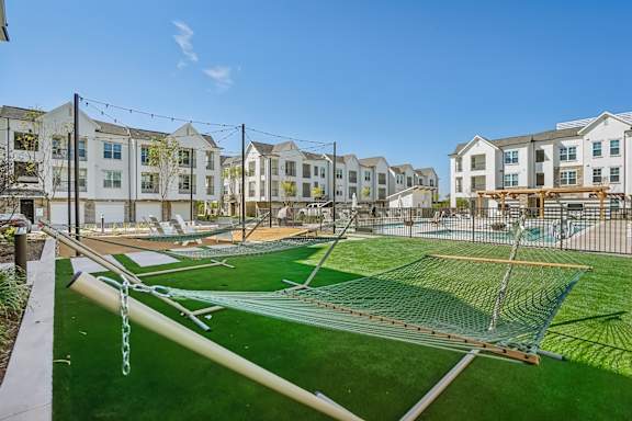 a soccer field with nets and apartments in the background