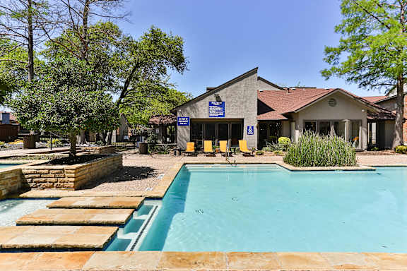 A pool with a building in the background.