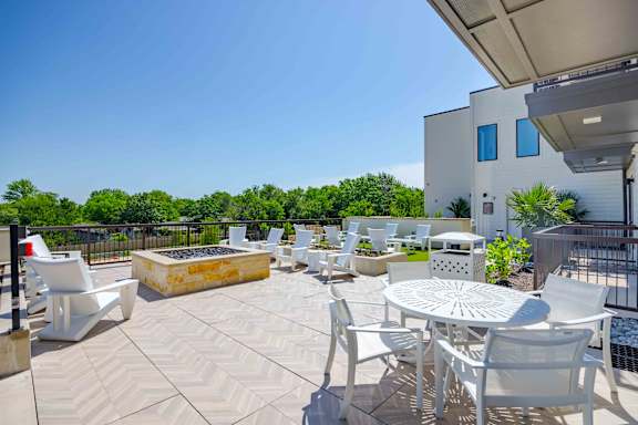 A patio with white furniture and a white table.