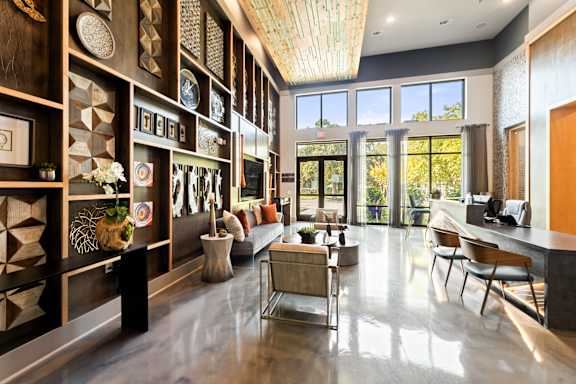 A modern living room with a long wooden shelf on the wall.