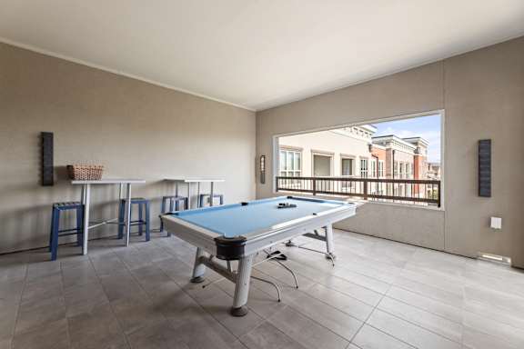 A pool table in a room with a view of the city.