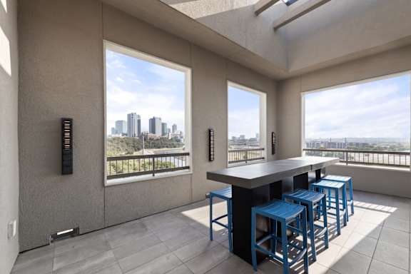 A modern kitchen with a bar stool and a view of the city.