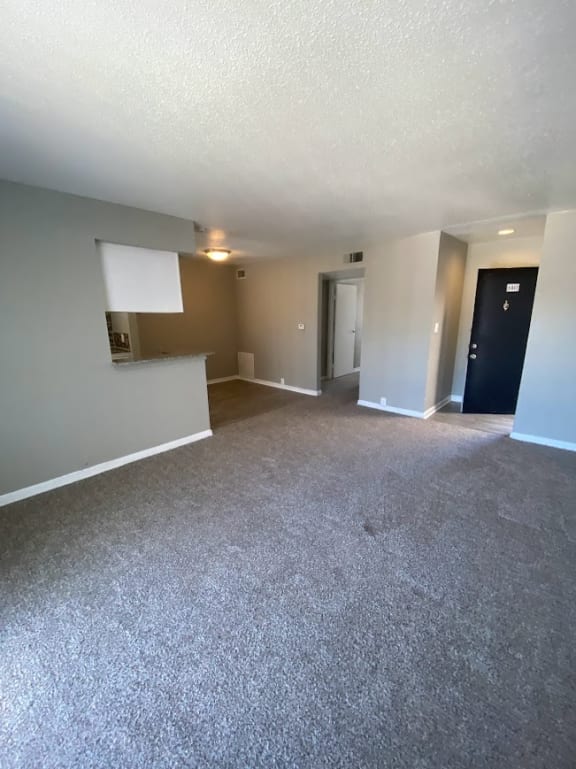 an empty living room with white carpeting and white walls