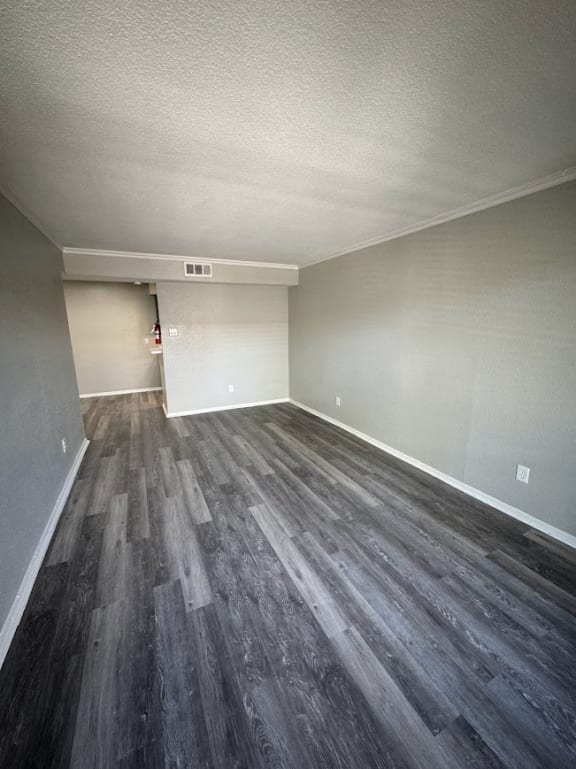 an empty living room with wood flooring