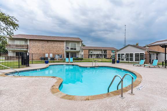 A swimming pool in a residential area with a fence around it.