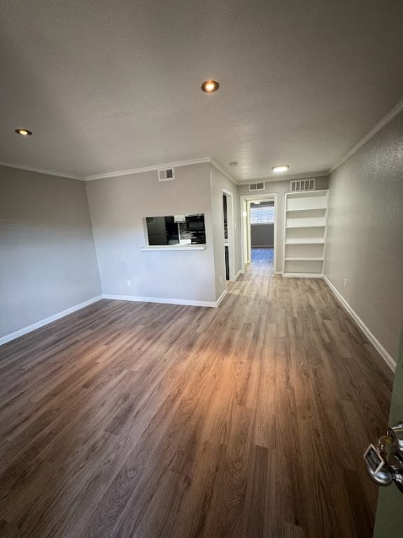 an empty living room with wood floors and a tv
