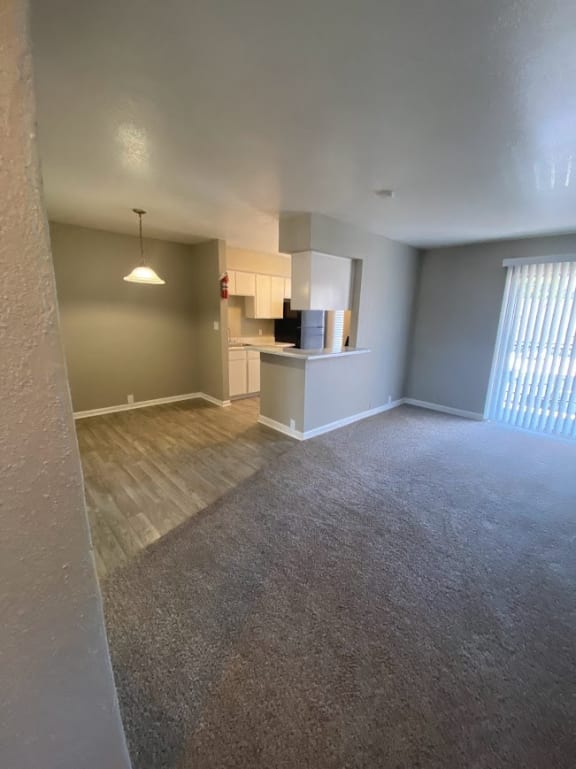 an empty living room with a kitchen in it