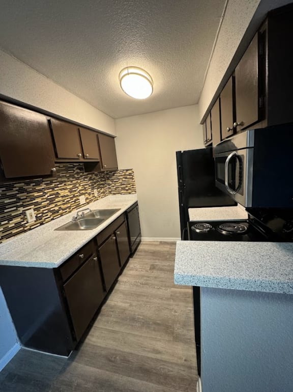 a kitchen with a sink and a stove and a microwave