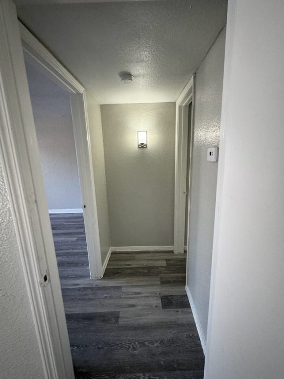 a hallway with a door open and a light on the wall