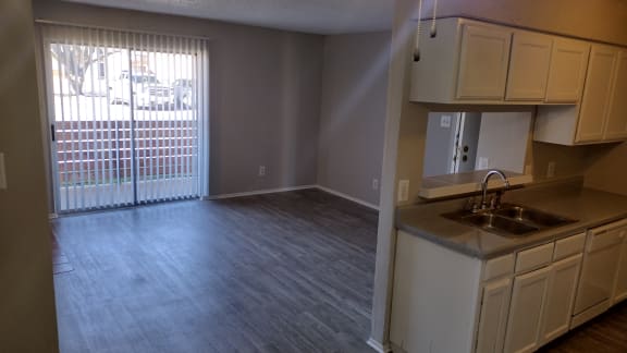 an empty kitchen and living room with a sliding glass door