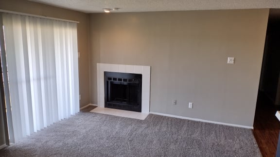 the living room has a fireplace and a window with curtains