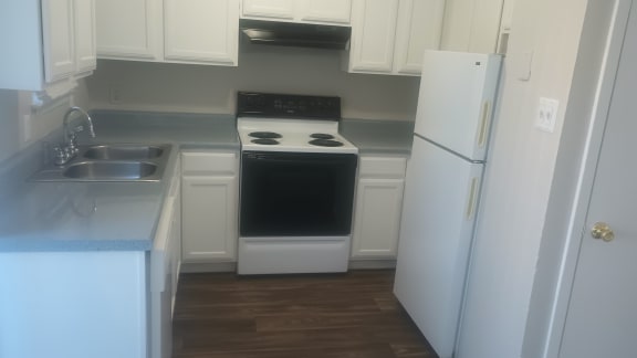 a kitchen with white cabinets and a stove and a refrigerator